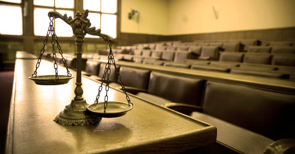 Balança da justiça em foco em um tribunal vazio para pesquisa de antecedentes.